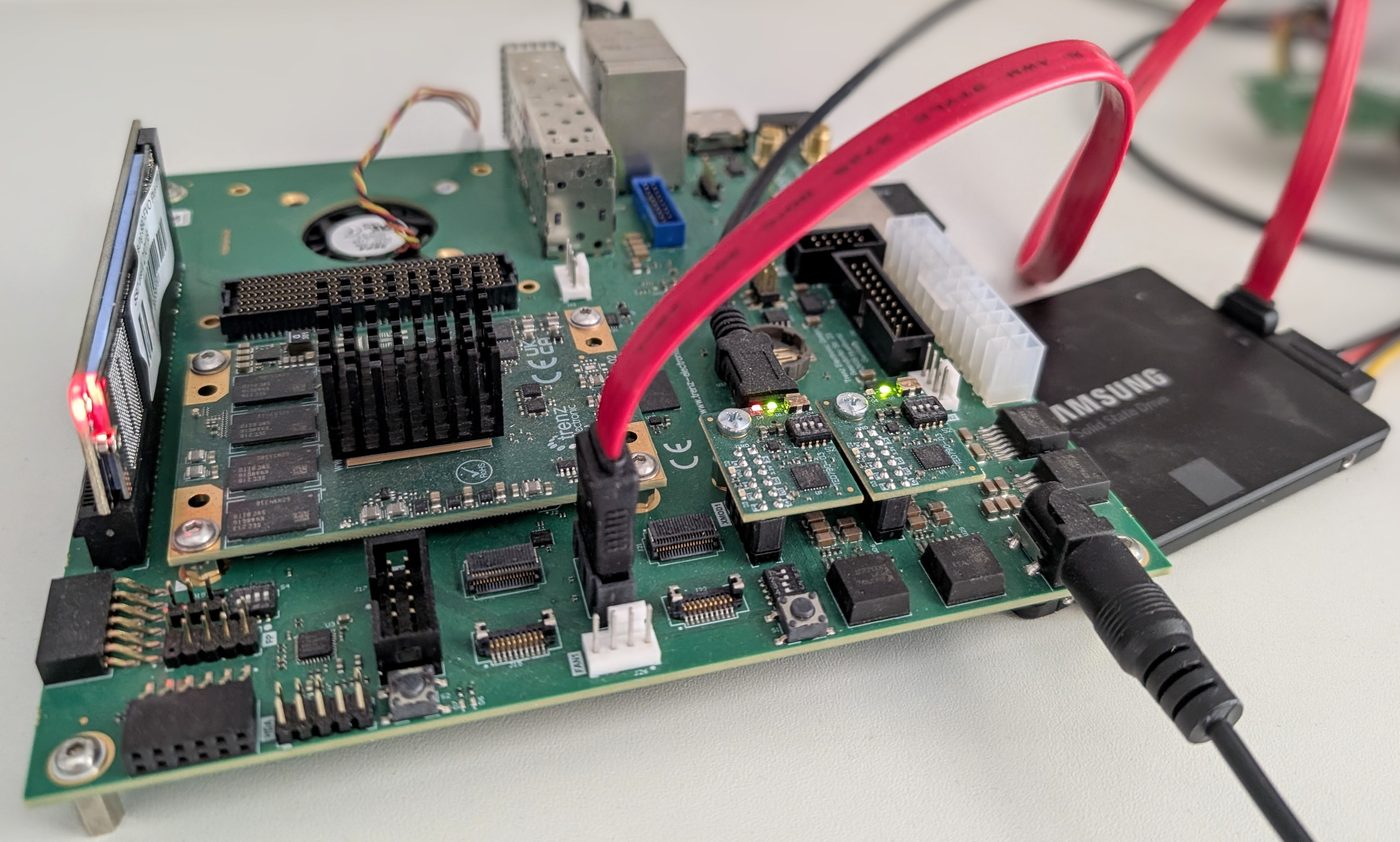 A Trenz Electronic system-on-module seated on its carrier board, with an SSD connected over SATA and power and ribbon cables running off the bench